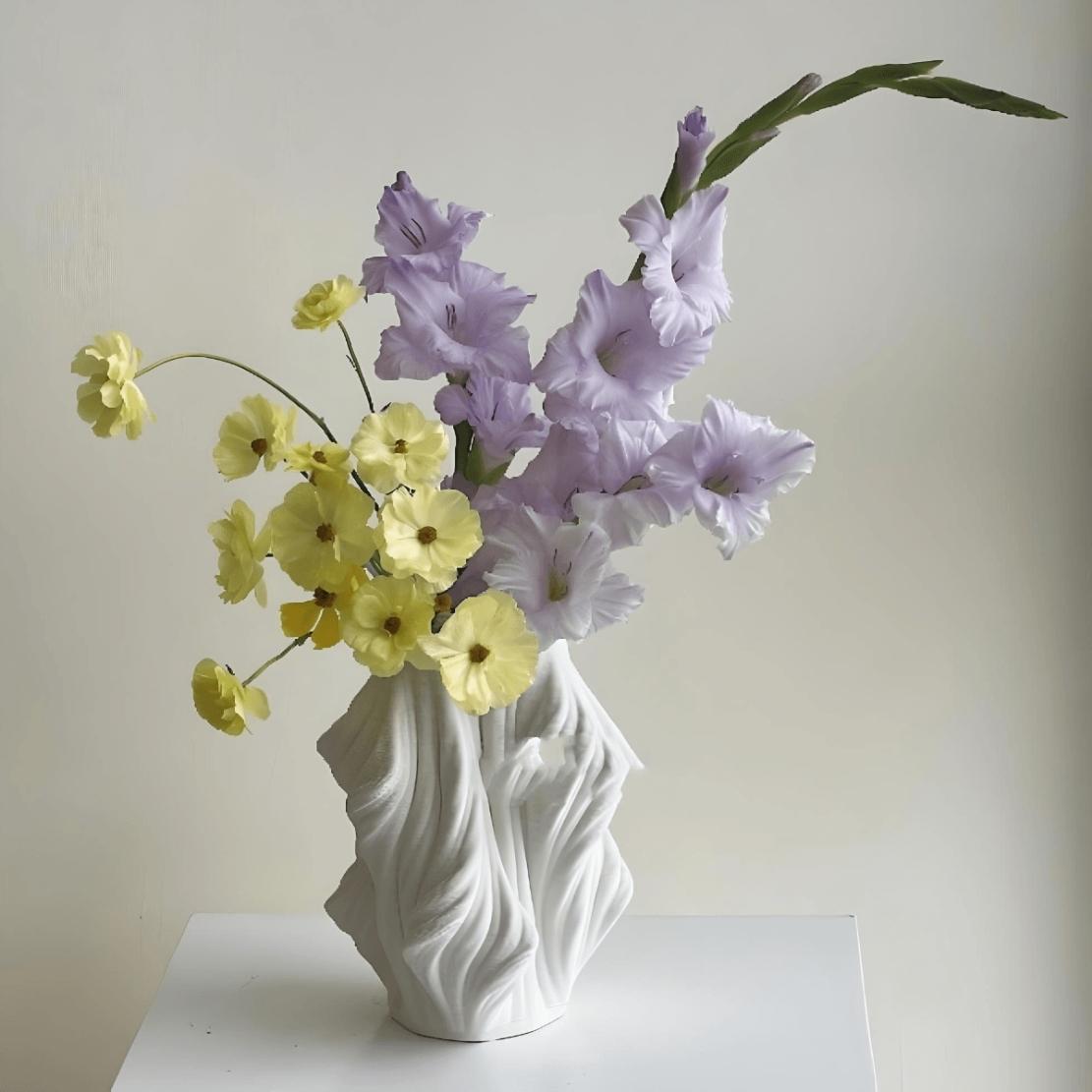 White, ceramic, asymmetrical vase with yellow and purple flowers
