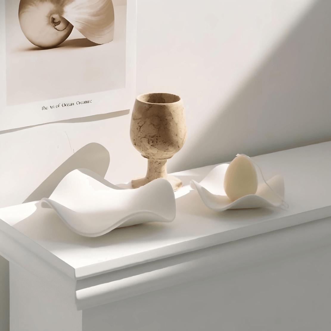 White, minimalist, ceramic wave bowls on shelf