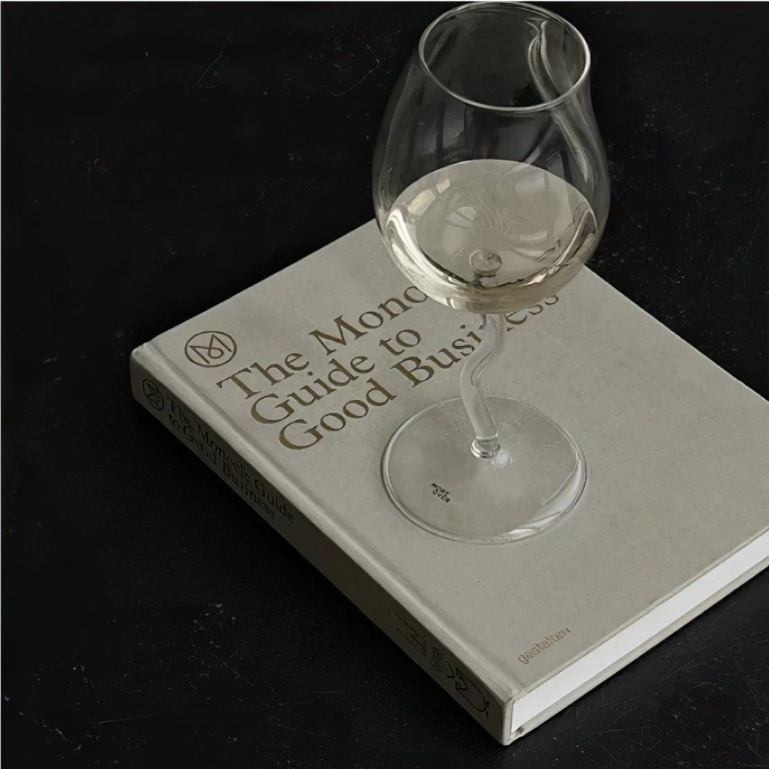 Wiggle stem glass with white wine on a book