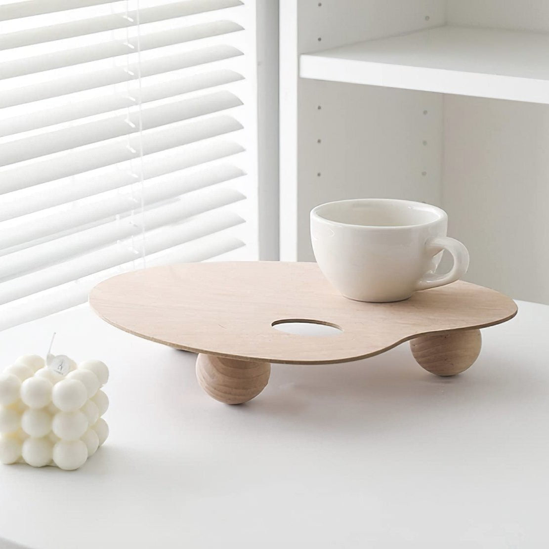 Elevated wooden paint palette tray with white tea cup and candle